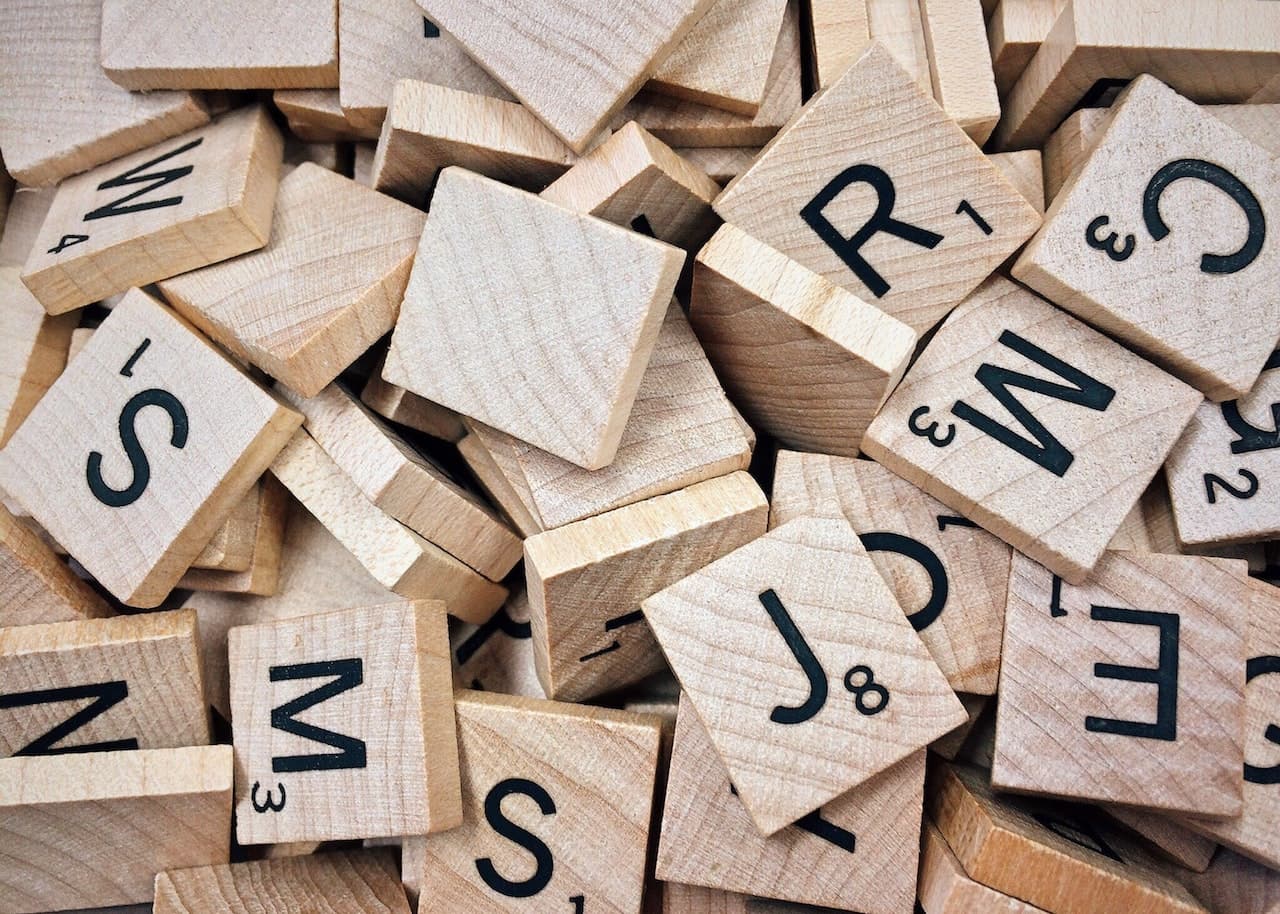 Tessere di legno con stampa di lettere e numeri (pedice)in nero. Le domande a risposta multipla seguono di solito un ordine alfabetico o numerico per indicare la progressione.