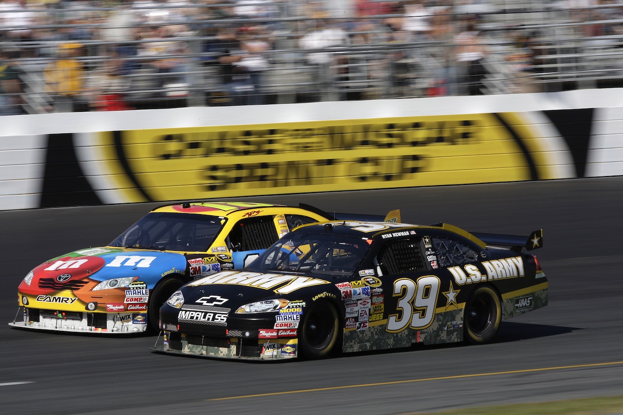 Due macchine da corsa NASCAR che si muovono in un tratto della pista con velocità e accelerazione costante.