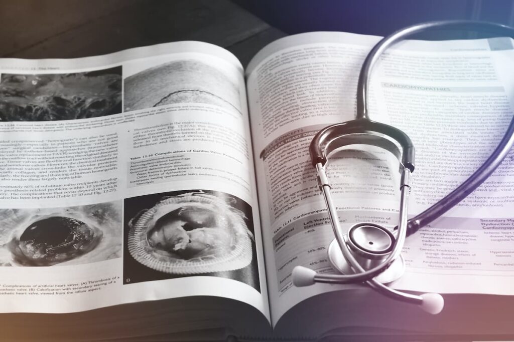 Libro aperto con uno stetoscopio posato sulla pagina a destra.