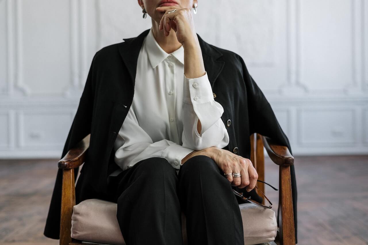 Psicoterapeuta seduta su una poltrona. Indossa una camicia bianca e sulle spalle ha una giacca nera.