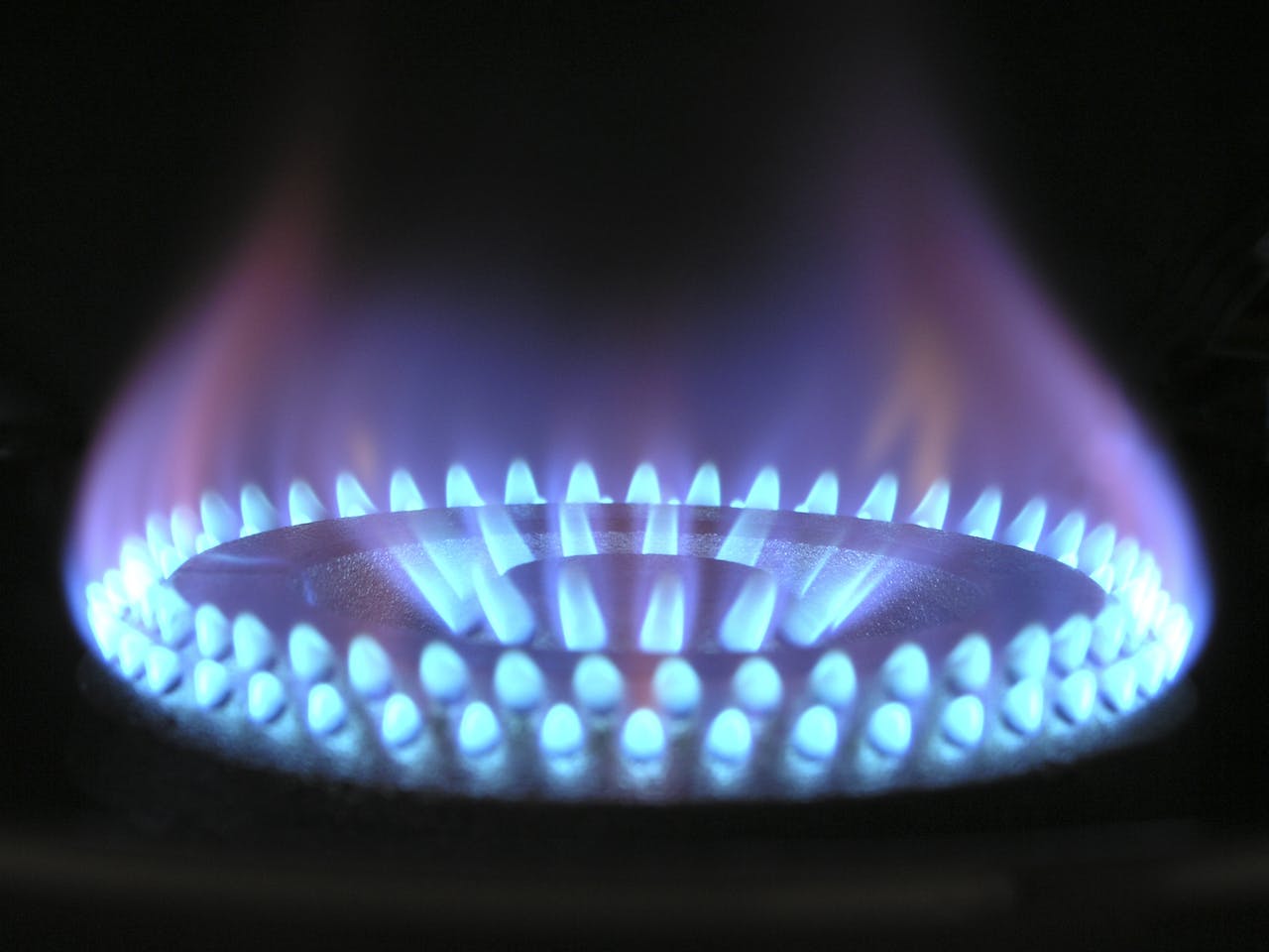 Fornello a gas attivo mentre rilascia calore e aumenta la temperatura di una pentola.