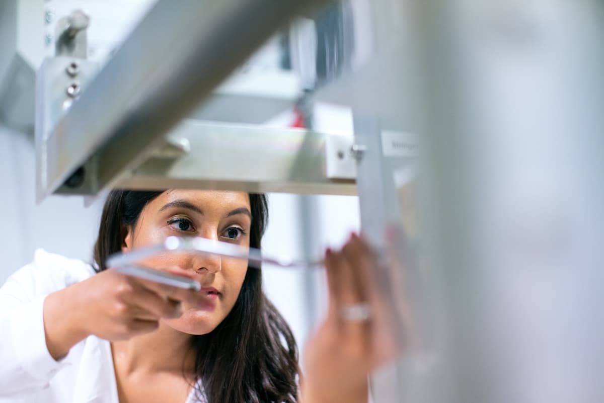 Studentessa di medicina mentre utilizza uno strumento in laboratorio.